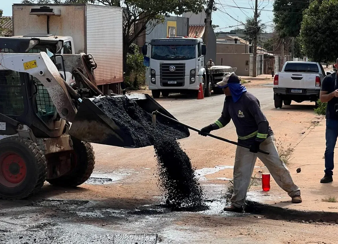 Equipe de trabalho em frente de tapa-buracos em Campo Grande